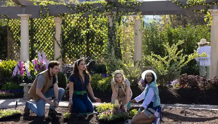 Main cast of Grosse Pointe Garden Society standing tensely in a garden club setting, hinting at secrets and betrayal as Season 2 approaches.