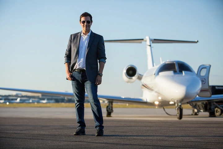Harry Hedaya smiling near a private jet, symbolizing business success in 2025