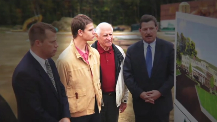 John Chakalos with business partners at a real estate project site, reviewing development plans.