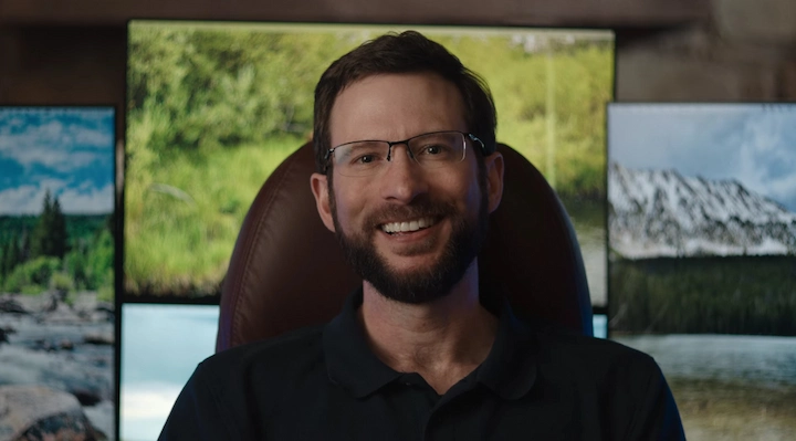 Justin Posey smiling in casual shirt and cap, featured in Justin Posey’s Net Worth 2025 article.