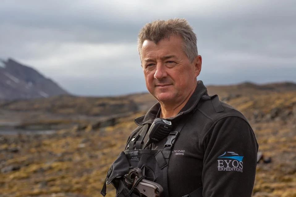 Rob McCallum wearing EYOS gear while standing in a rocky field during an expedition.
