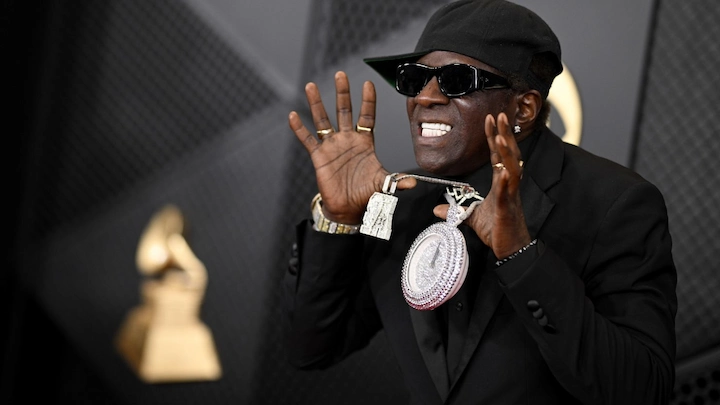 Flavor Flav in 2024 wearing his signature clock necklace, highlighting his music legacy, net worth, and reality TV career.