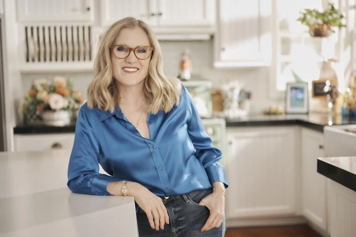 Nancy Cartwright, voice of Bart Simpson, smiling with animated backdrop, representing her career and net worth in 2025.