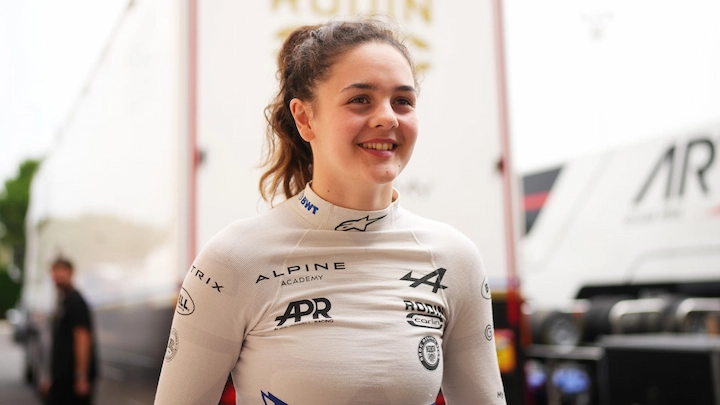 Abbi Pulling poses in full racing suit next to title about her net worth and racing career in 2025