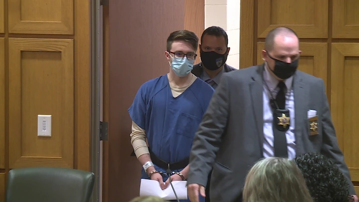 Chandler Halderson escorted in court in blue prison uniform after being found guilty of murdering parents.