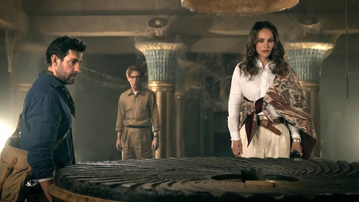 John Krasinski, Natalie Portman, and another character in an ancient underground chamber examining the Fountain of Youth.