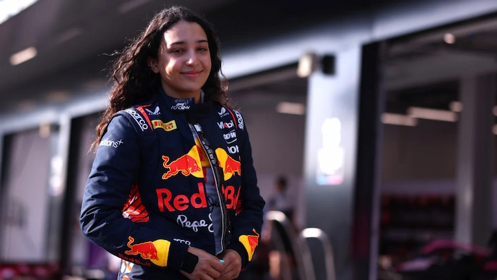 Hamda Al Qubaisi smiling in a Red Bull racing suit in the pit lane before a motorsport event