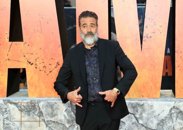 Jeffrey Dean Morgan posing playfully on the red carpet at a movie premiere.