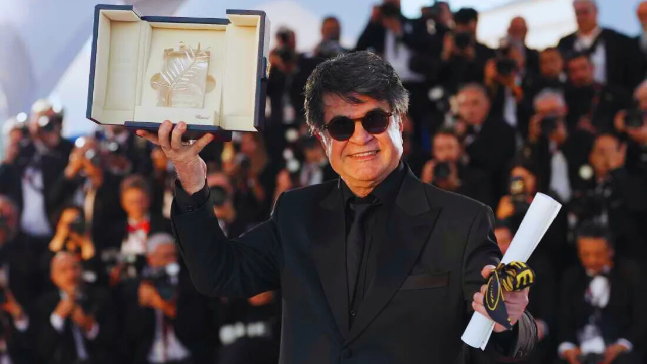 Iranian filmmaker Jafar Panahi holds Palme d'Or trophy at Cannes Film Festival 2025.