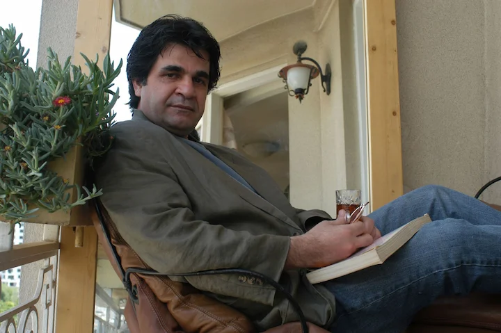 Jafar Panahi writing in a notebook while under house arrest in Iran.