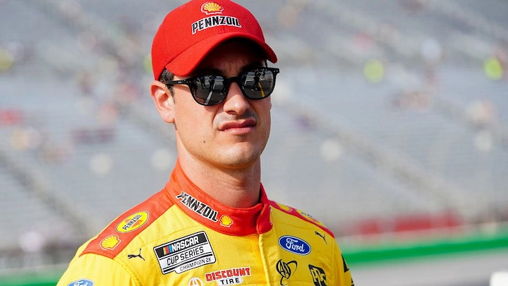 Joey Logano’s Net Worth 2025 headline image showing NASCAR champion in racing suit and career story.