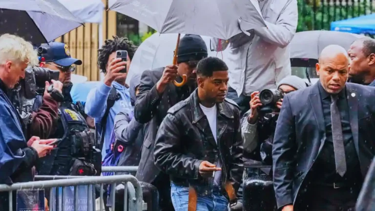 Kid Cudi walks through a crowd of reporters and photographers under umbrellas as he arrives at court to testify in the Diddy trial.