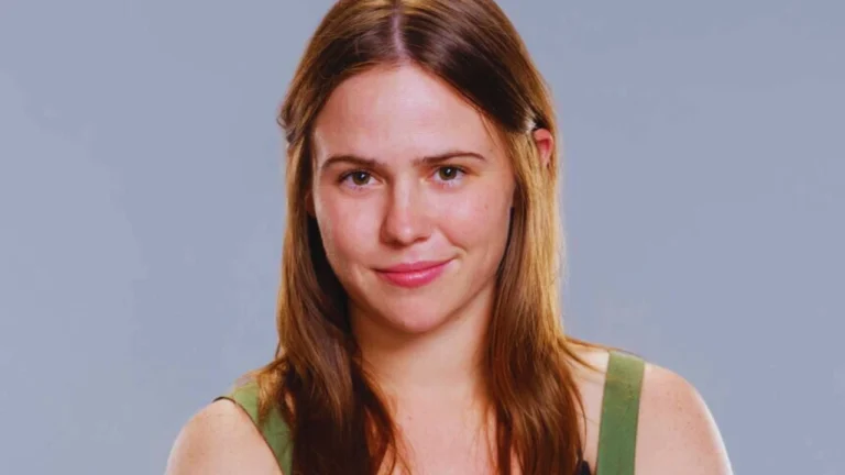 Mack Fitzgerald smiling confidently in a green top against a gray background on NBC's Destination X.