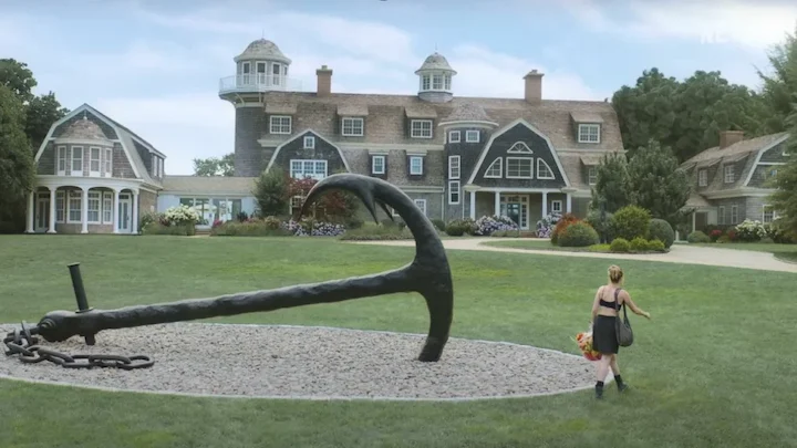 A wide view of the mansion from Netflix’s Sirens with a large anchor sculpture on the front lawn.