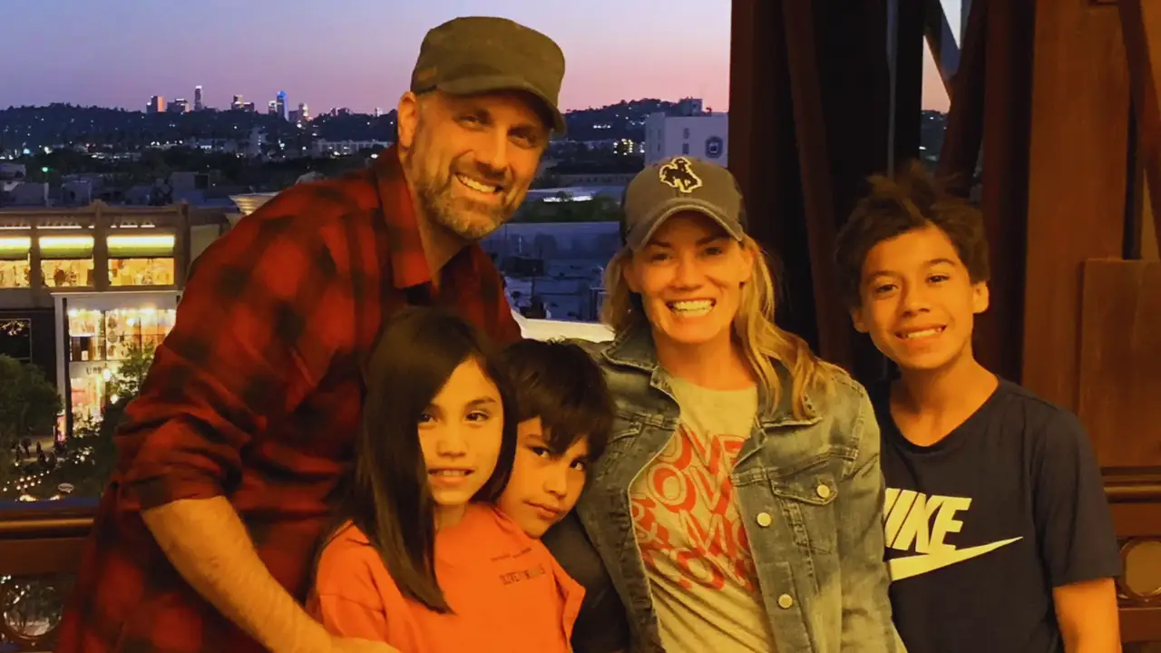 A warm family moment inspired by the movie Instant Family, showing adoptive parents bonding with children in a cozy living room setting, symbolizing real-life adoption stories.
