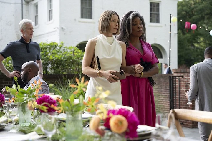 Two women standing together at outdoor party in The Better Sister show.
