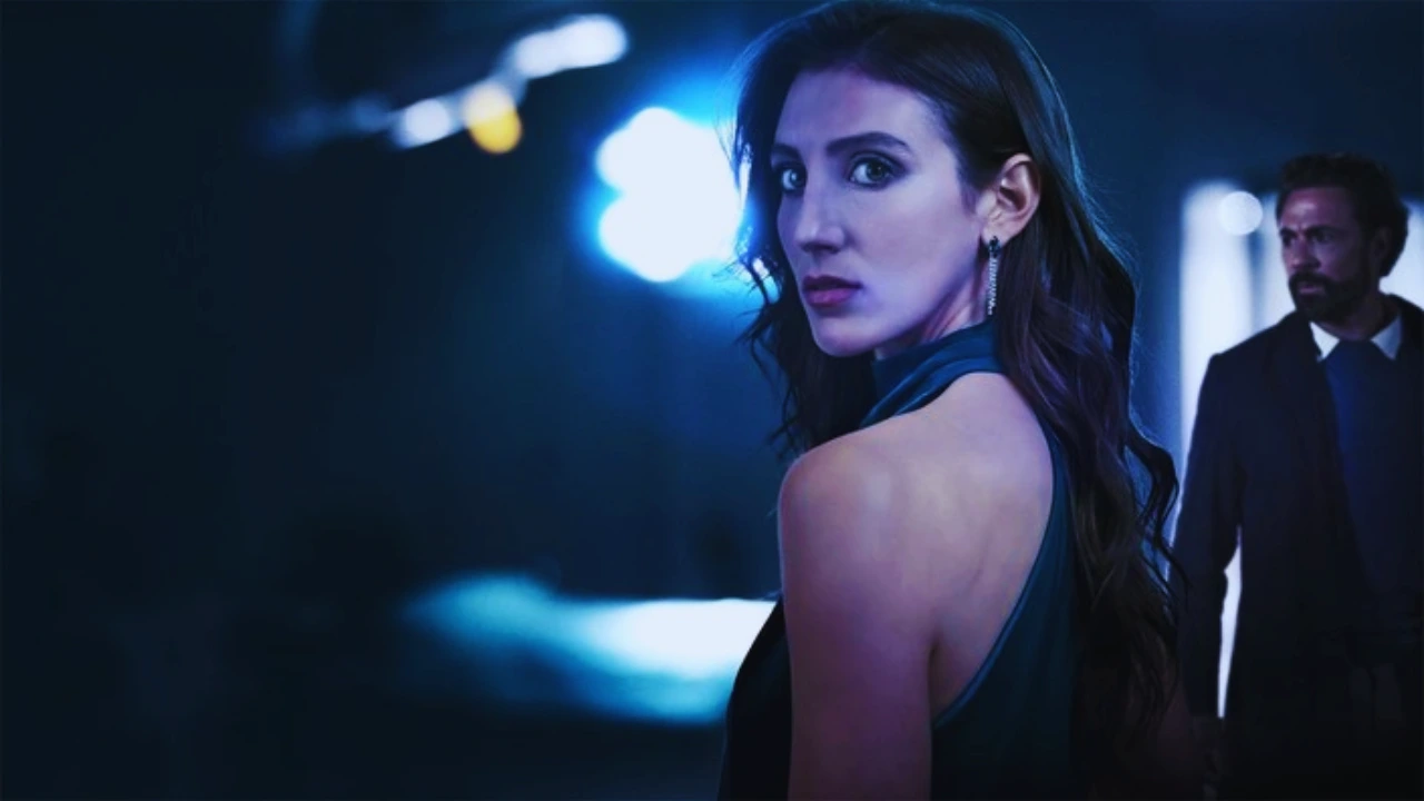 Woman in a dark dress looks back anxiously as a man stands behind her in a suspenseful scene.