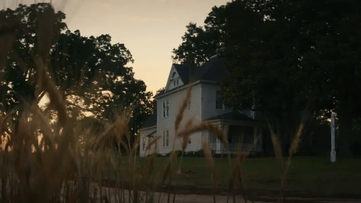 A quiet farmhouse at sunset surrounded by tall grass, one of the main filming locations in Georgia for The Woman in the Yard.