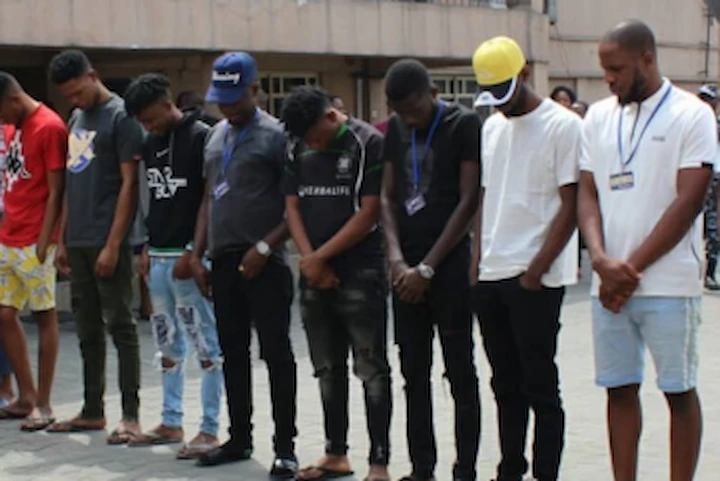 Yahoo Boys operating online scams, symbolizing Nigeria’s cybercrime network and its global impact through romance fraud and dark rituals.