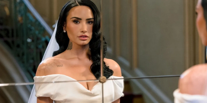 Close-up of Demi Lovato in a Vivienne Westwood bridal gown, gazing into a mirror before her wedding.