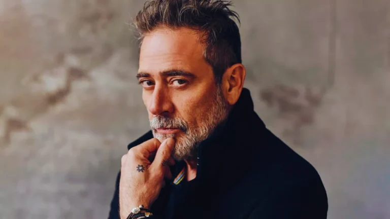 Jeffrey Dean Morgan posing in a thoughtful stance with a rugged expression and greying beard.