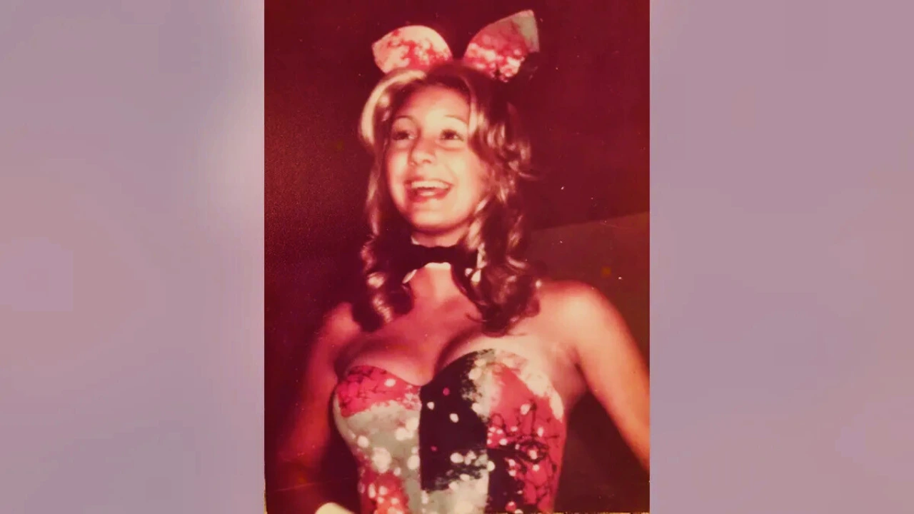 Adrienne Pollack smiling in a floral Playboy Bunny costume with matching ears and a black bow tie.