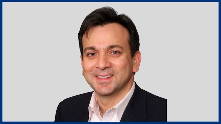 Professional headshot of Amir Wain, founder and CEO of i2c Inc., smiling in business attire.