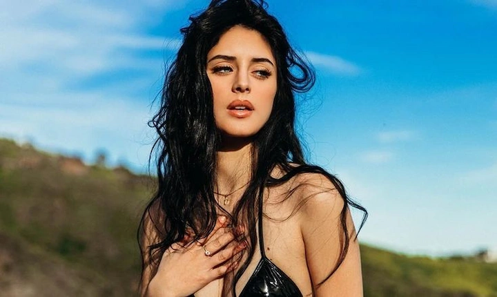 Camilla Araujo posing outdoors in black top, stylish look with natural makeup and loose hair