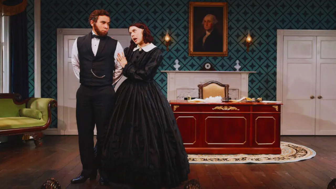 Cole Escola as Mary Todd Lincoln in Oh, Mary! standing by desk with George Washington portrait.