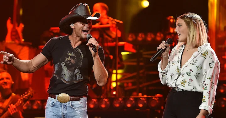 Tim McGraw performing onstage with daughter Gracie McGraw during a live concert.