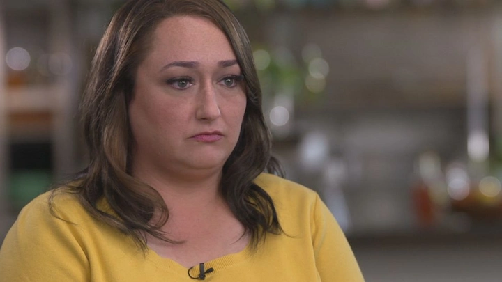 Heather Robinson interview screenshot showing her in yellow sweater with serious expression.