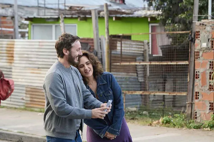 Smiling Juan and Valeria bonding in their community in The Heart Knows Netflix film.