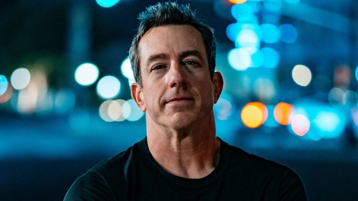 Jamie Lissow portrait with blurred city lights in the background, showcasing his 2025 public image