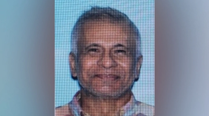 Portrait of Johnny Soekhies, a middle-aged man smiling gently against a neutral background.