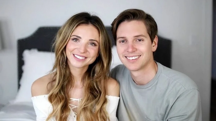 Jordan Ramirez smiling with his wife Sofia Bennett, happy couple portrait on a bed background.