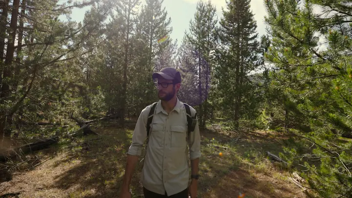 Justin Posey smiling in casual shirt and cap, featured in Justin Posey’s Net Worth 2025 article.