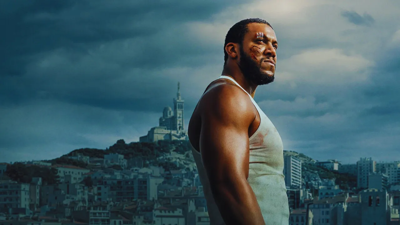 Bastien, bruised and contemplative, gazes over Marseille’s cityscape, embodying guilt and resolve.