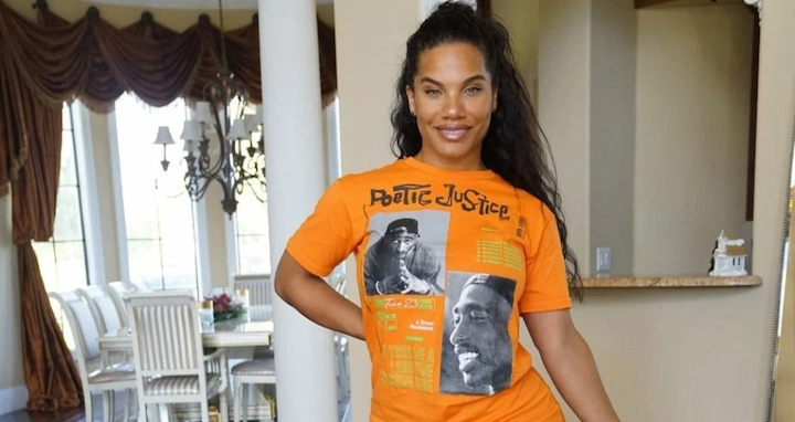 Kathy Drayton wearing orange Poetic Justice T-shirt, smiling at home, featured in 2025 net worth article.