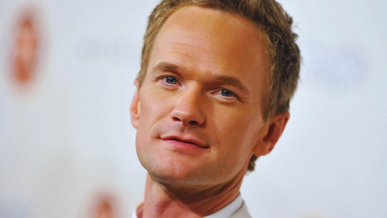 Headshot of Neil Patrick Harris smiling confidently at an event, soft lighting highlighting his friendly expression.