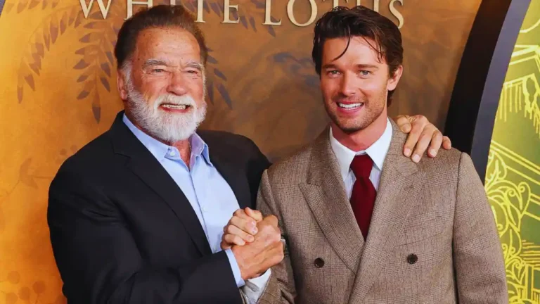 Arnold Schwarzenegger and son Patrick smiling and shaking hands at premiere event.