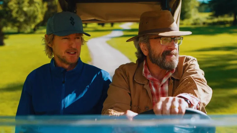 Owen Wilson and Marc Maron ride in a golf cart scene from Apple TV+ series Stick on a golf course.
