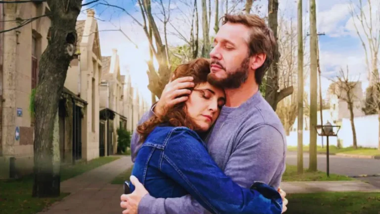 Man and woman hugging on a sunny street scene from The Heart Knows Netflix movie.