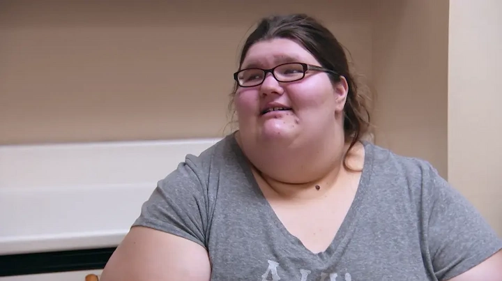 Megan Davis smiling and looking hopeful after weight loss while seated in a doctor’s office proudly!